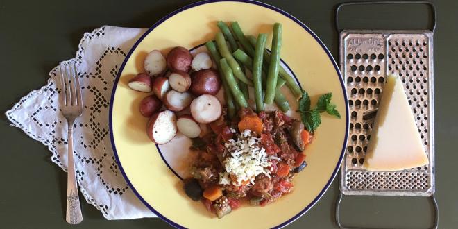 a plate of ground turkey cooked with vegetables, with potatoes and green beans